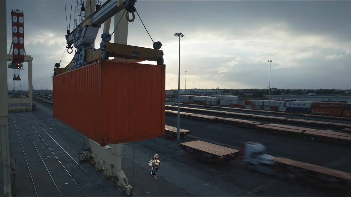 Container lifted by a gantry crane over a rail yard